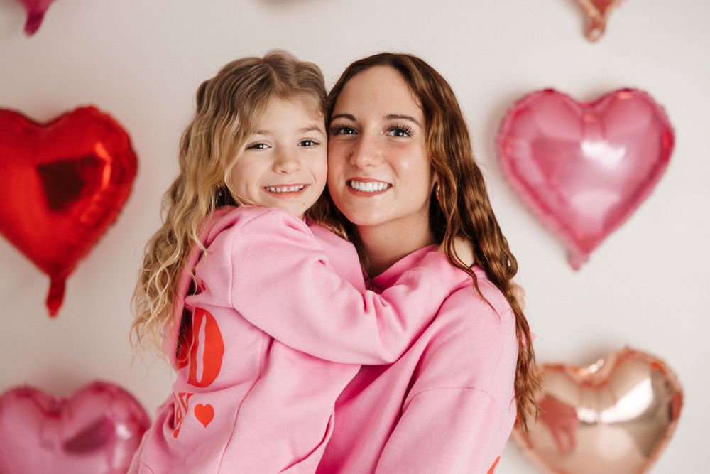 Sister Valentine's Day Mini session in pink outfits with heart backdrop-NEPA children and family photographer.