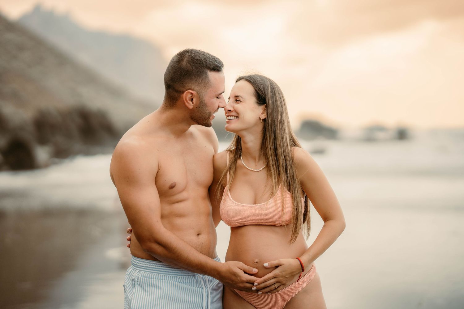 A serene maternity photoshoot at Playa Bollullo, Tenerife, Canary Islands. Celebrating the beauty of motherhood by the ocean's waves.