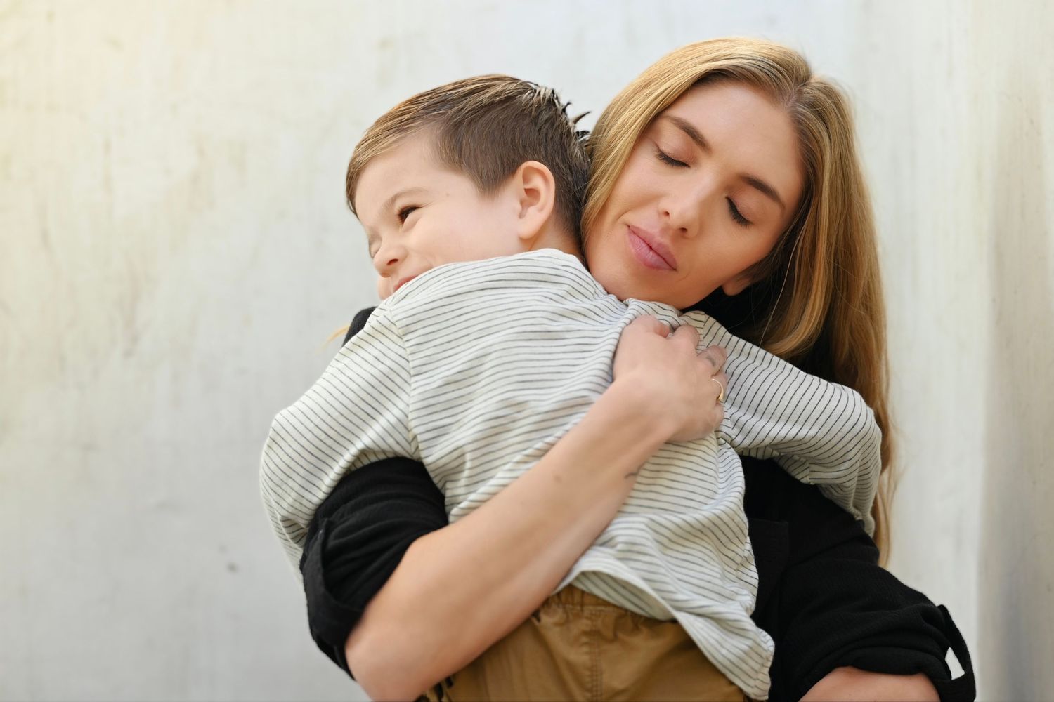 Intimate black and white portraits showing tender embraces between parent and child.