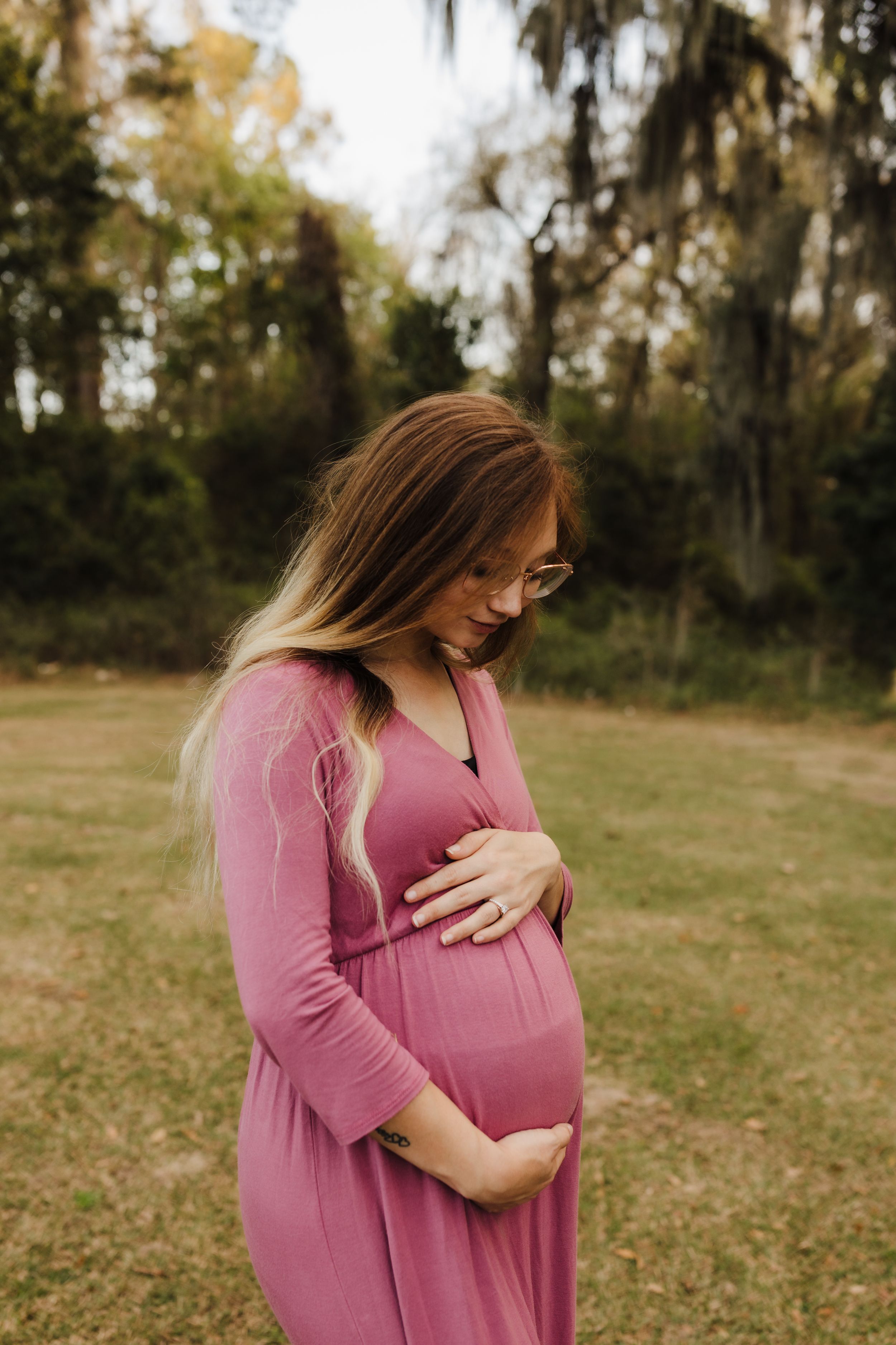 A peaceful maternity moment captured with soft lighting and natural outdoor scenery.