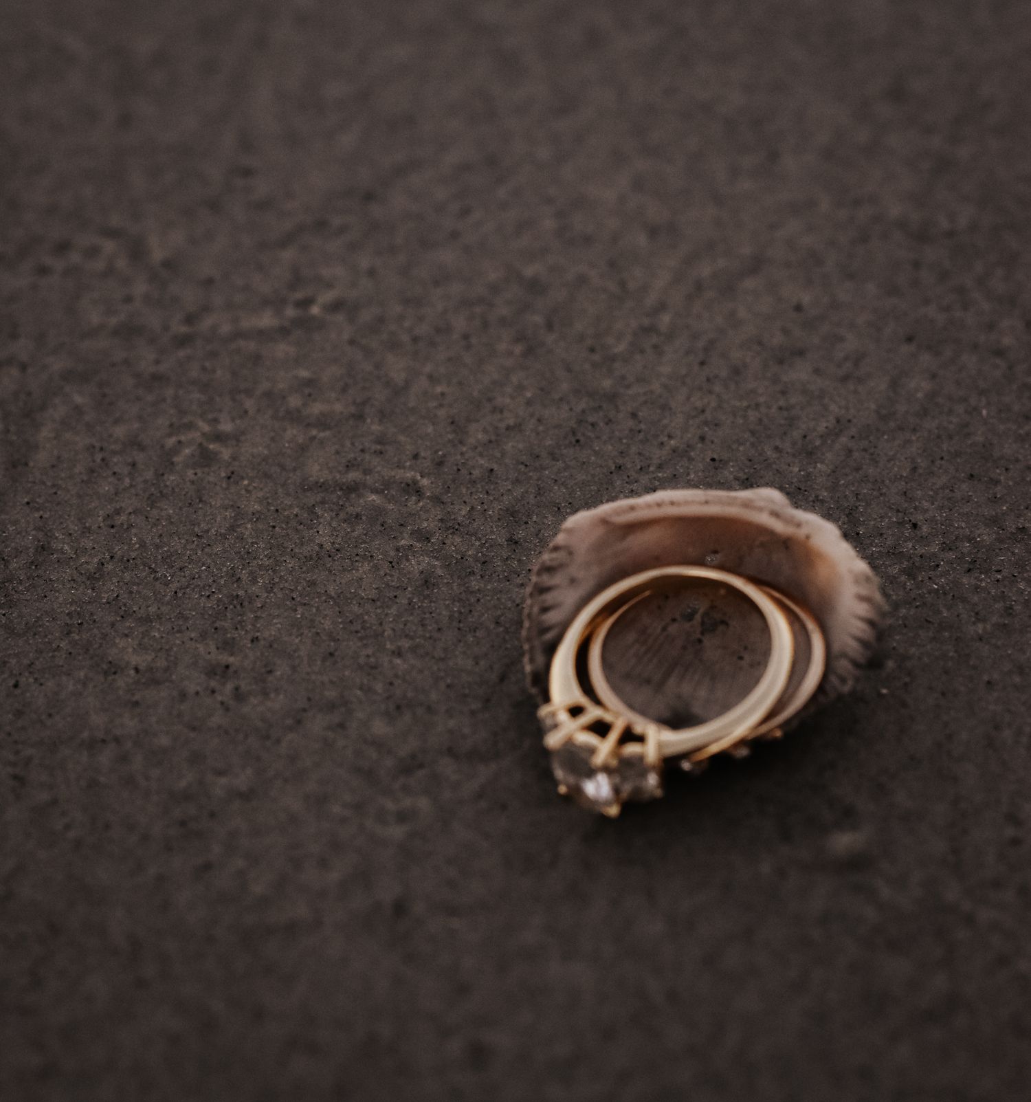 Vintage engagement rings lying on dark textured surface.