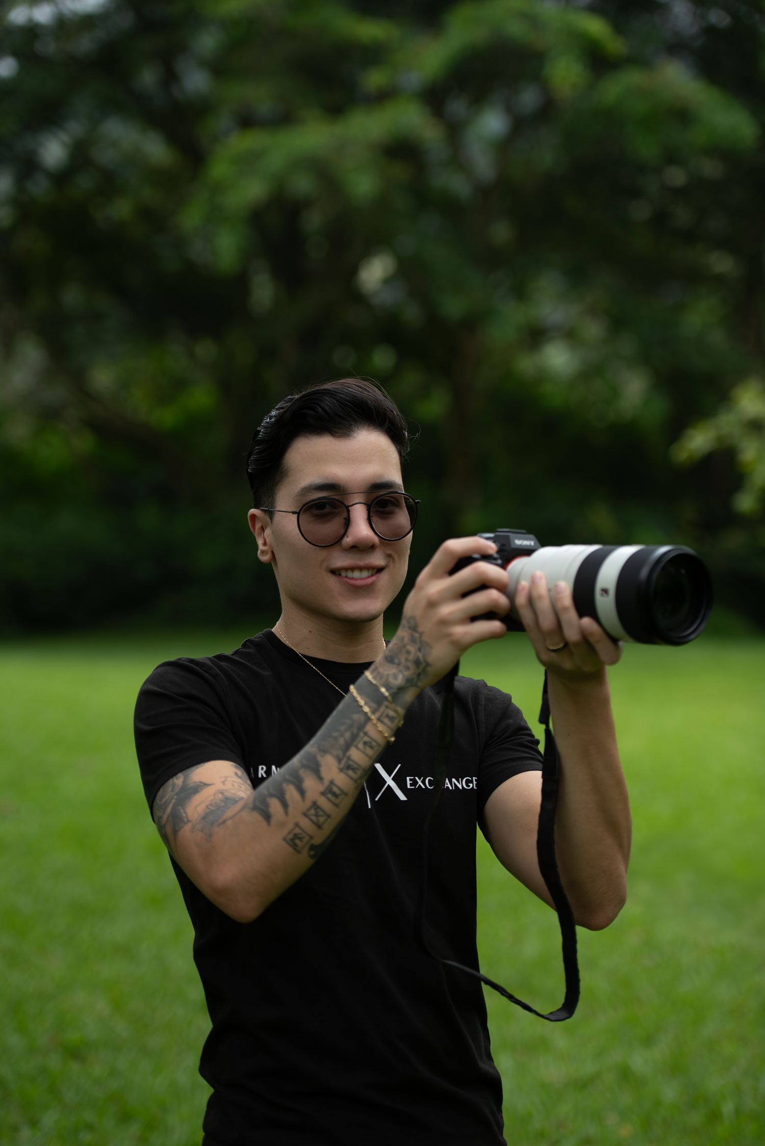 Photographer in Oahu, Hawaii holding his camera with a mountain background