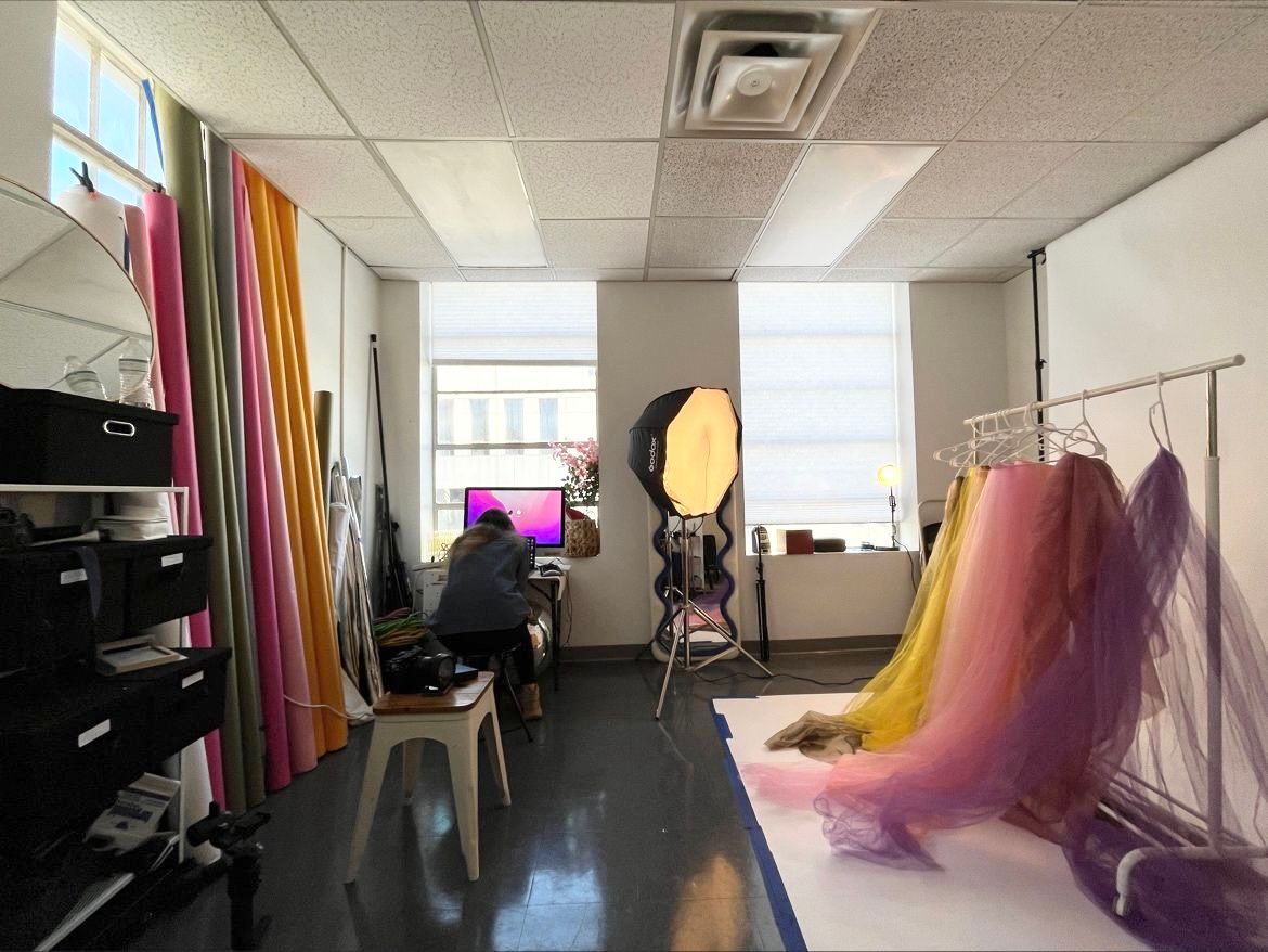 Photo studio setup with colorful curtains and lighting equipment.
