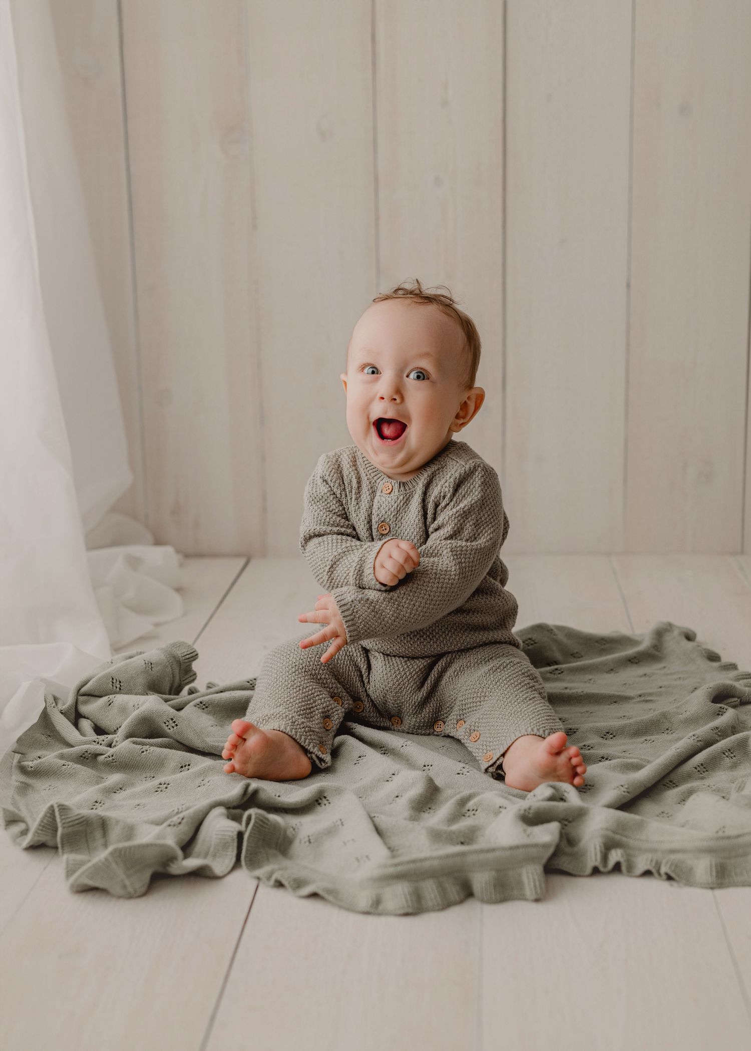 Several vintage-style portrait photographs in white frames arranged on a light neutral surface with soft decorative elements. MI studio