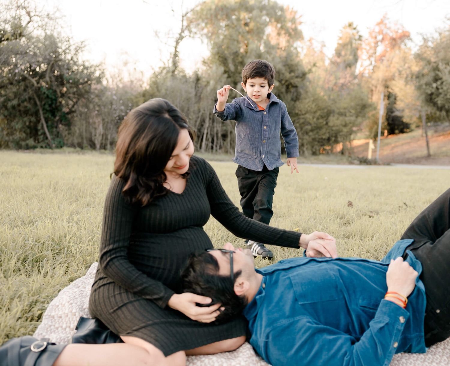 Pregnant mom smiling with family during golden hour maternity session in Fremont, CA
