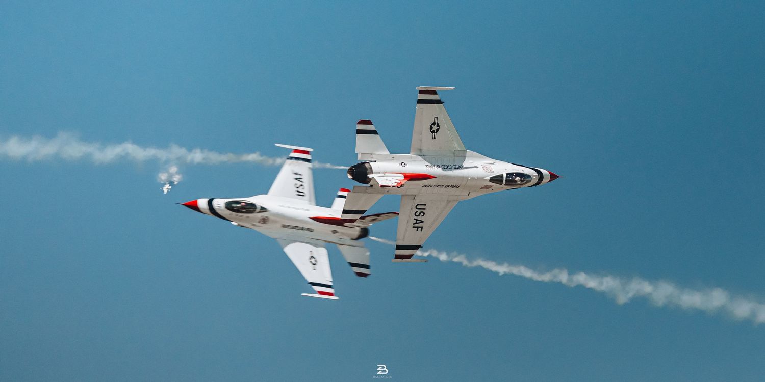 Two Thunderbirds performing precision pass in opposite directions