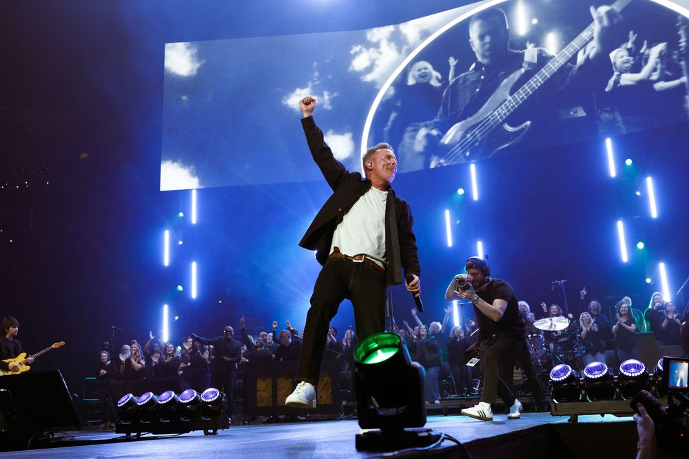 Chris Tomlin's annual Good Friday show at Bridgestone Arena in Nashville TN with blue neon lights and large screen backdrop at live concert.