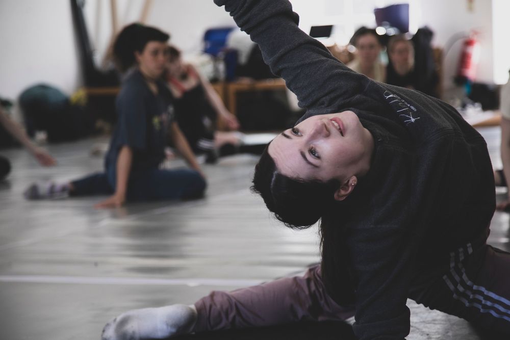 Students practice grappling techniques during a Brazilian Jiu-Jitsu training session on mats at a martial arts gym.