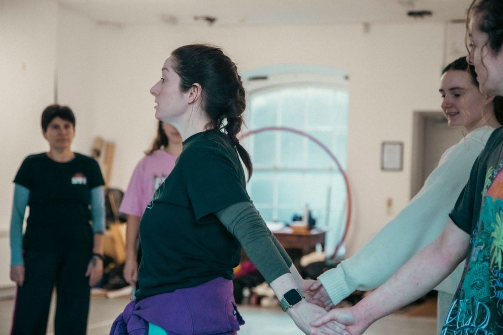 Group of people participating in a fitness class with exercise equipment in a bright studio setting.