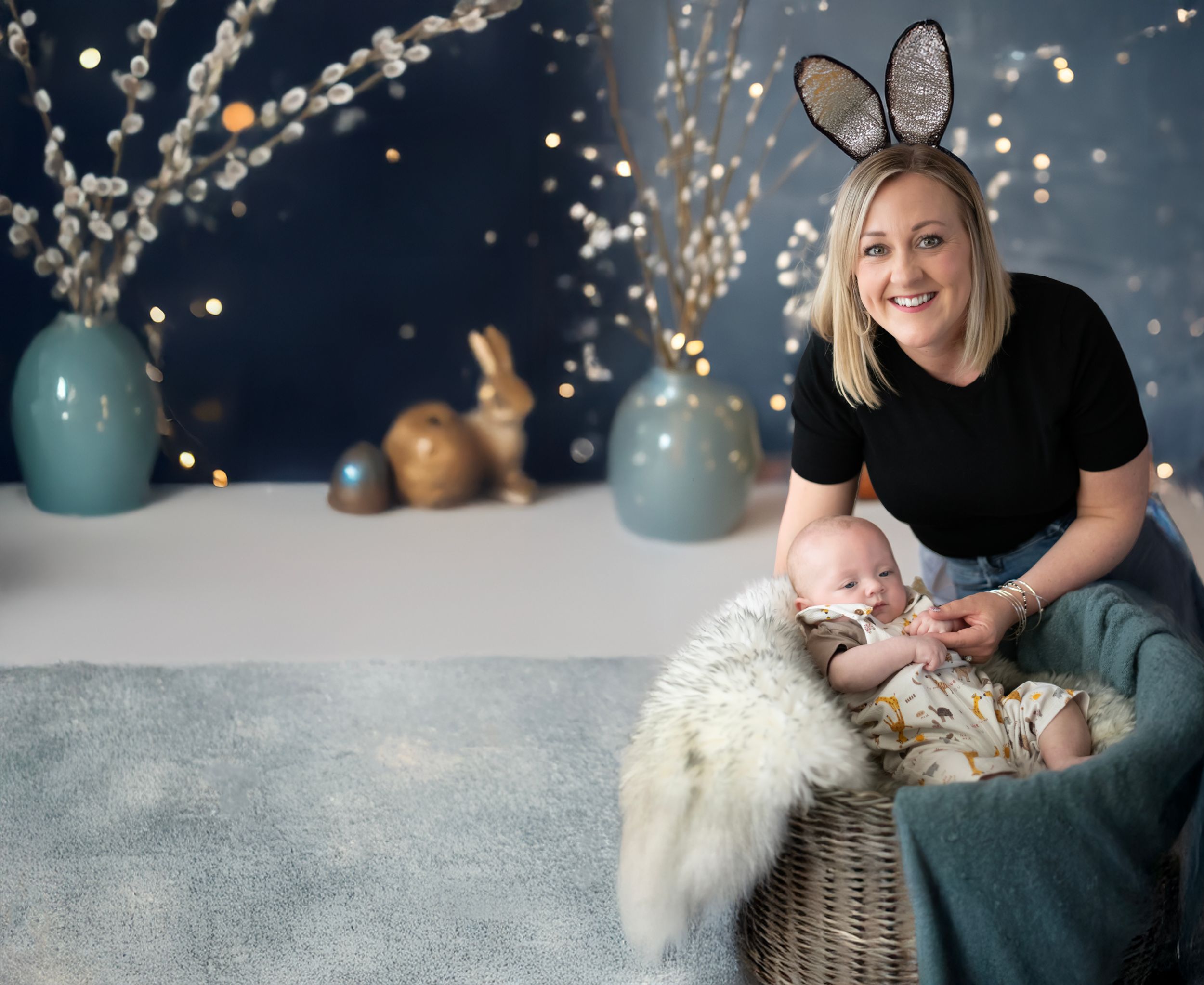 Easter themed portrait setup with bunny ears, turquoise vases, and decorative twinkle lights against a navy backdrop.