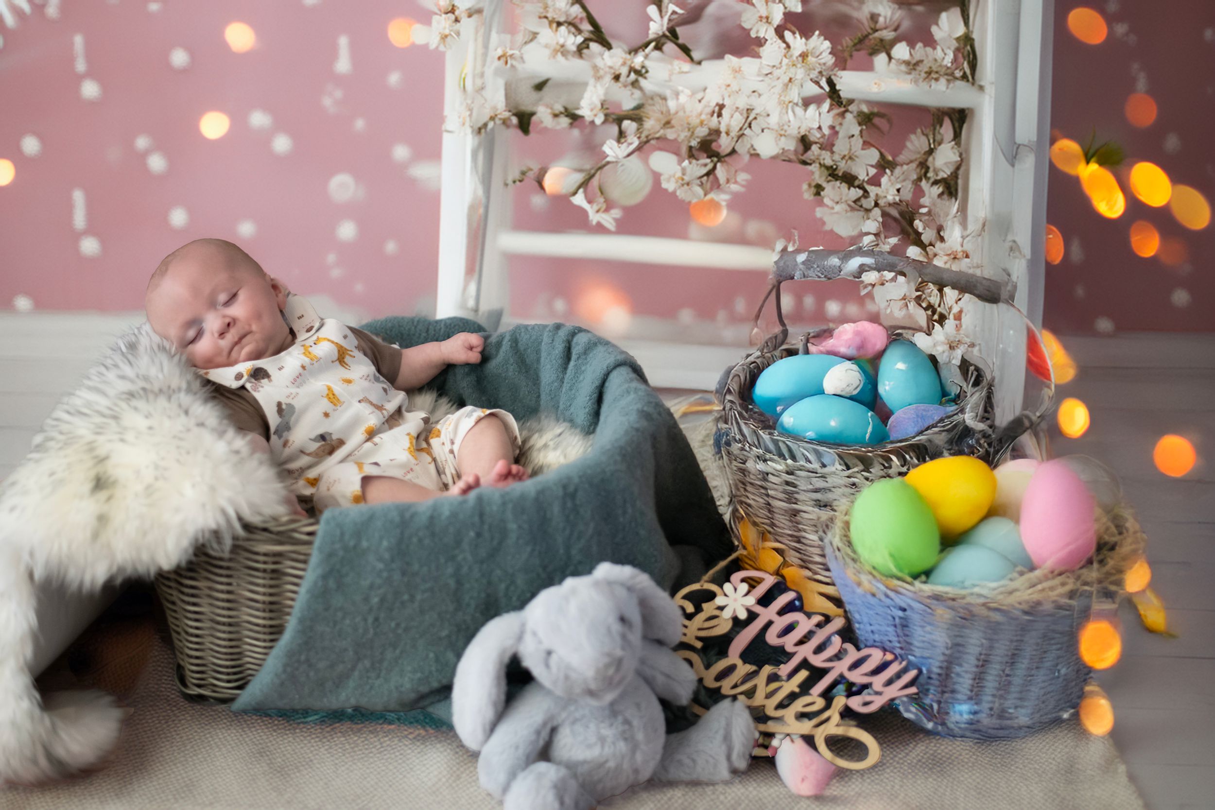 Easter holiday decorations with pastel colored eggs, flowers, bunny plush toy, and soft blanket in gentle spring setting.