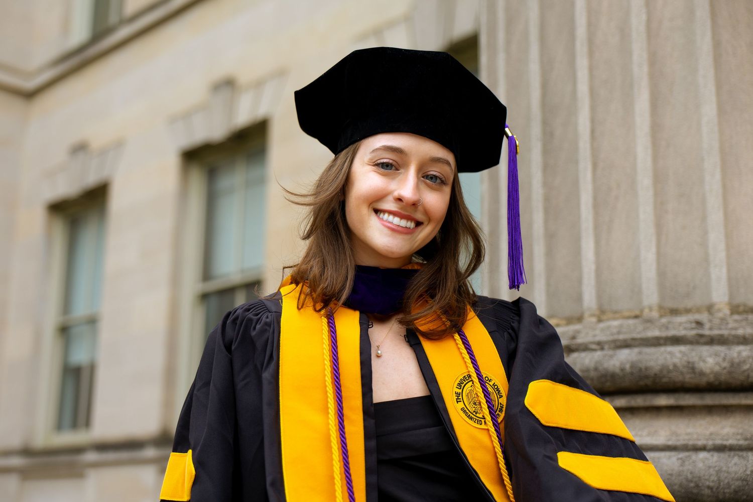 A portrait of a woman wearing a graduation gown