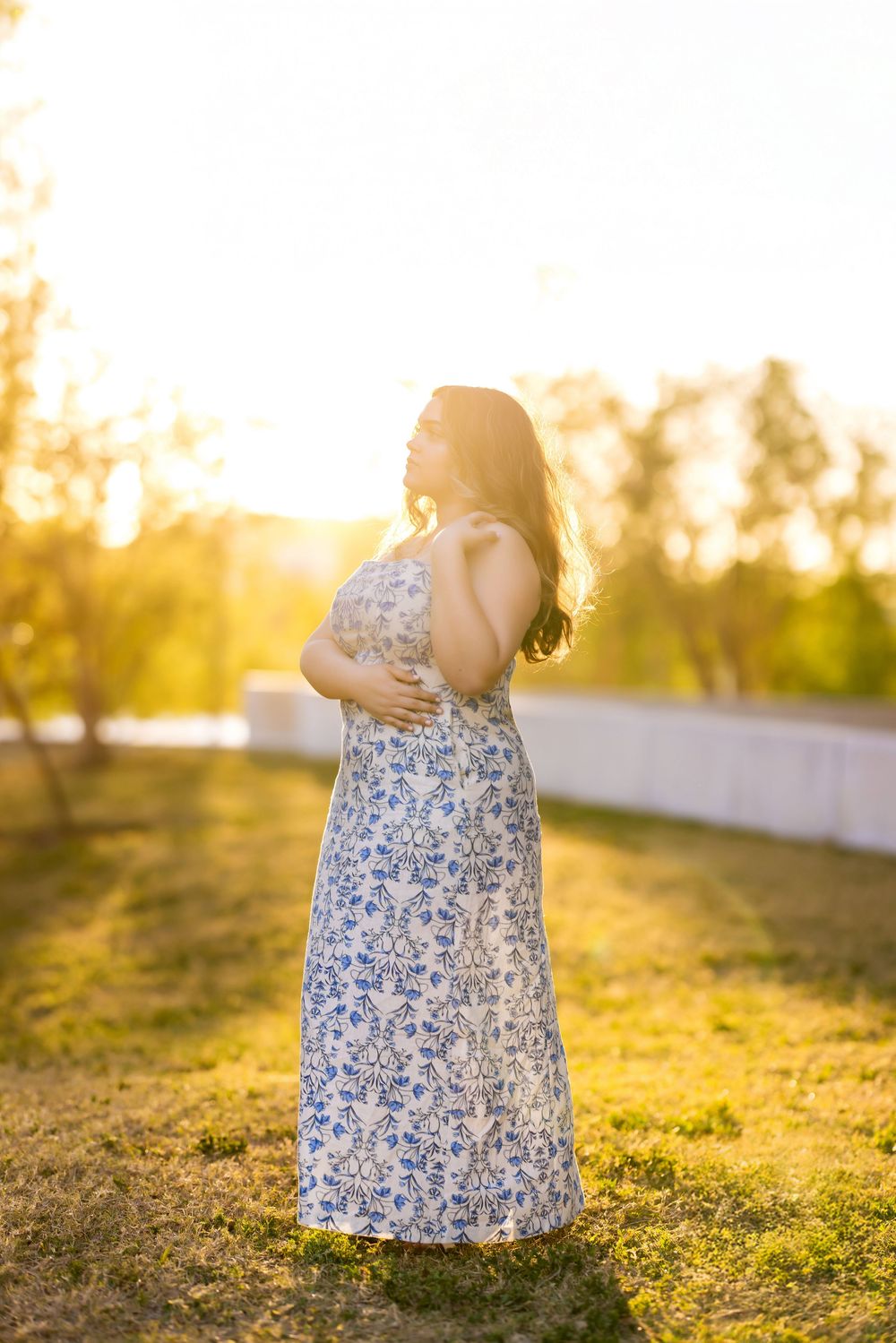 A floral dress captured in warm evening sunlight on grassy terrain.