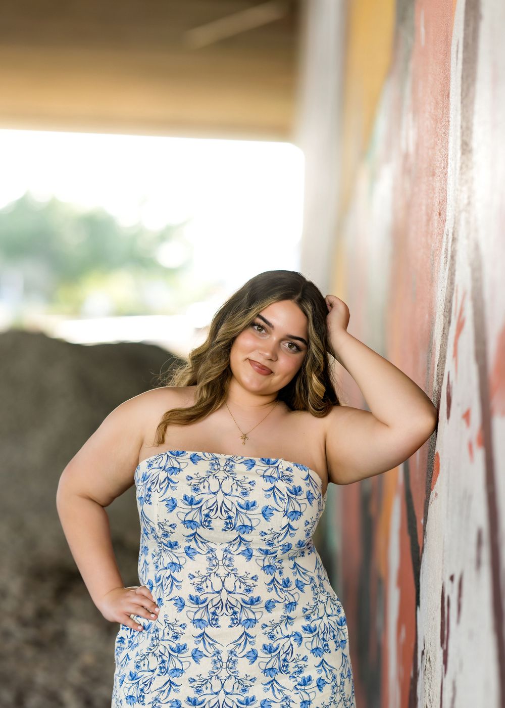 Strapless blue and white dress photographed against a textured wall background.