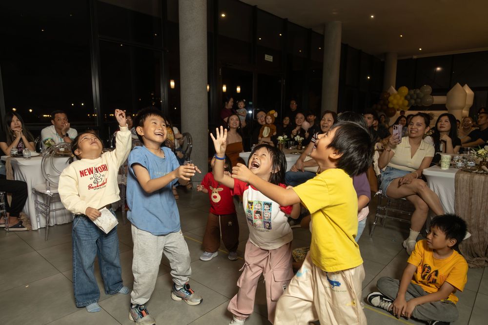 Group dancing and celebrating at a party in an indoor venue with nighttime lighting.