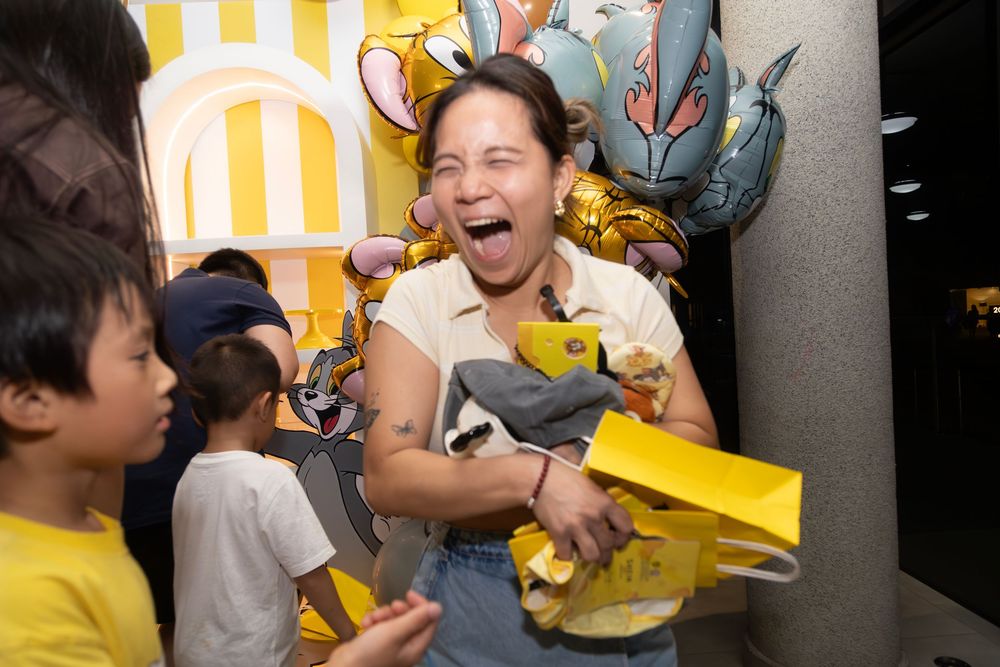 Joyful celebration moment with children and toys in front of a colorful striped backdrop.