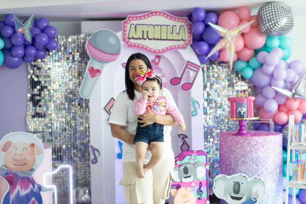 SING movie themed party setup with silver sequin backdrop and pastel balloon decorations.