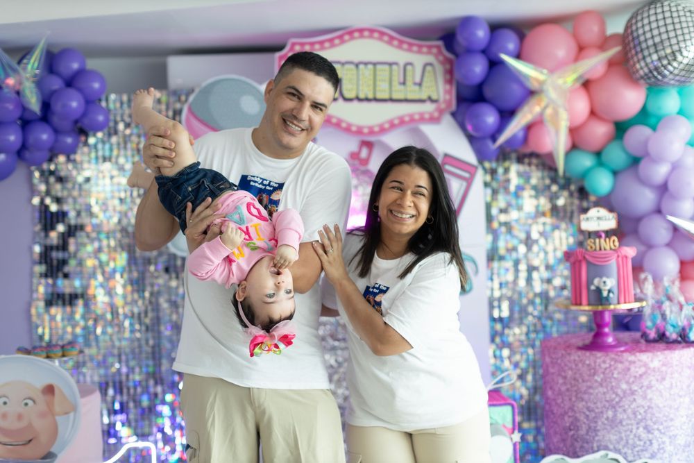 Party setup with SING movie theme featuring silver sequin wall and colorful balloon decorations.