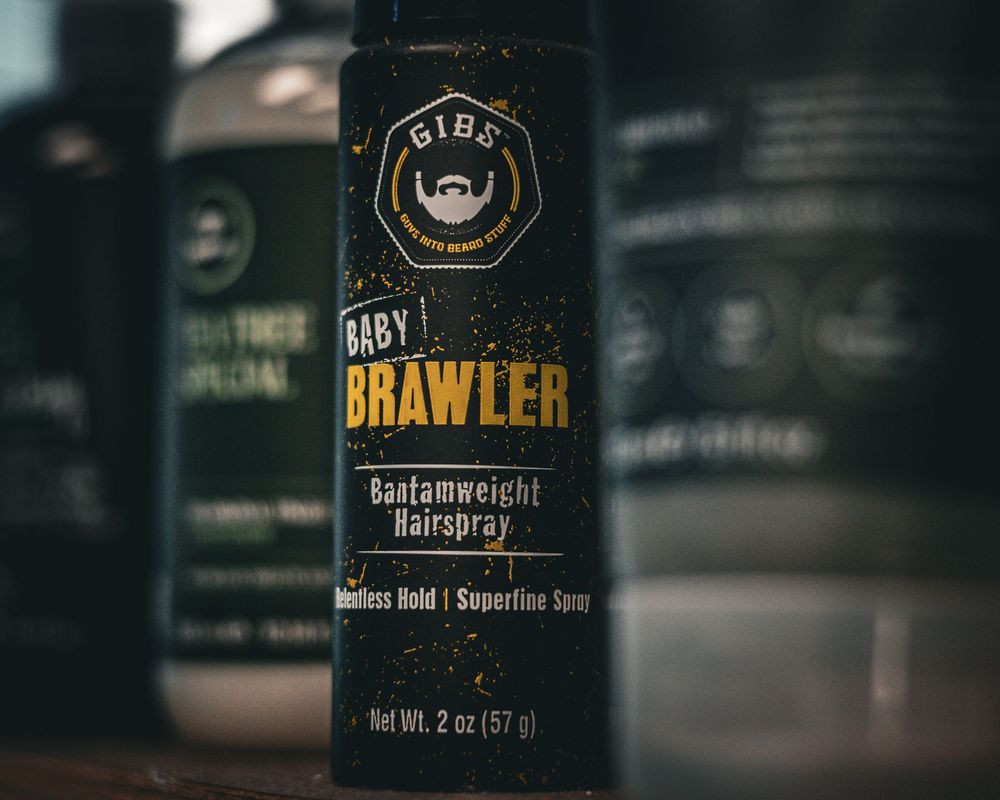 Close-up product shot of Brawler hair styling product container in moody lighting.