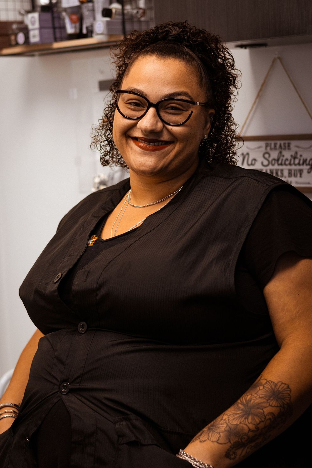Professional stylist in black attire showing personality in salon setting.