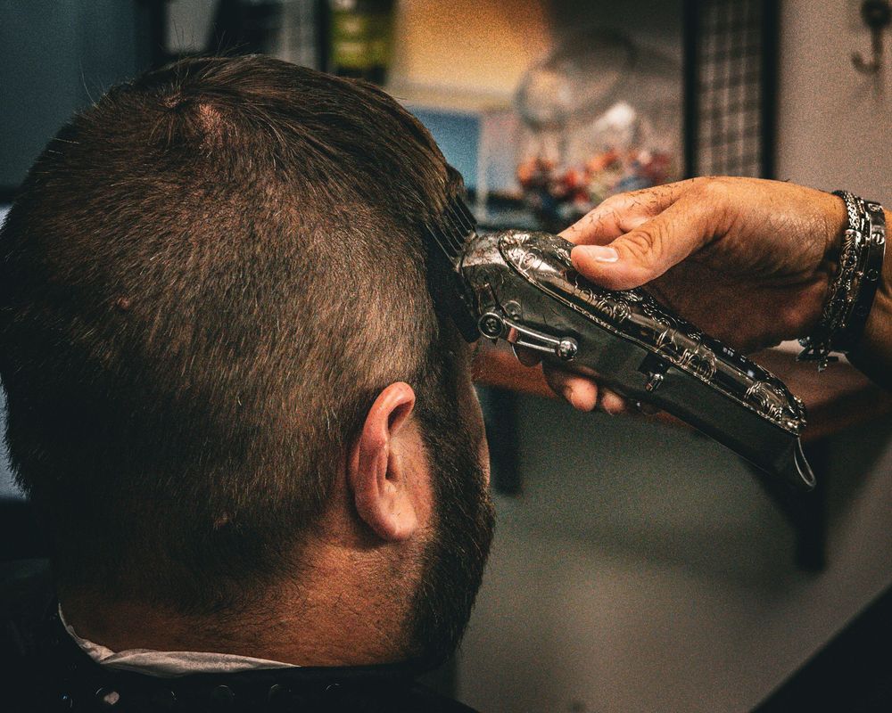 Close-up of hair trimming with professional clippers showing detailed grooming technique.