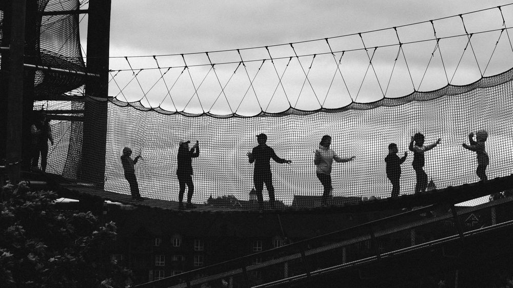 Silhouettes of visitors standing along a railing against a dramatic sky.