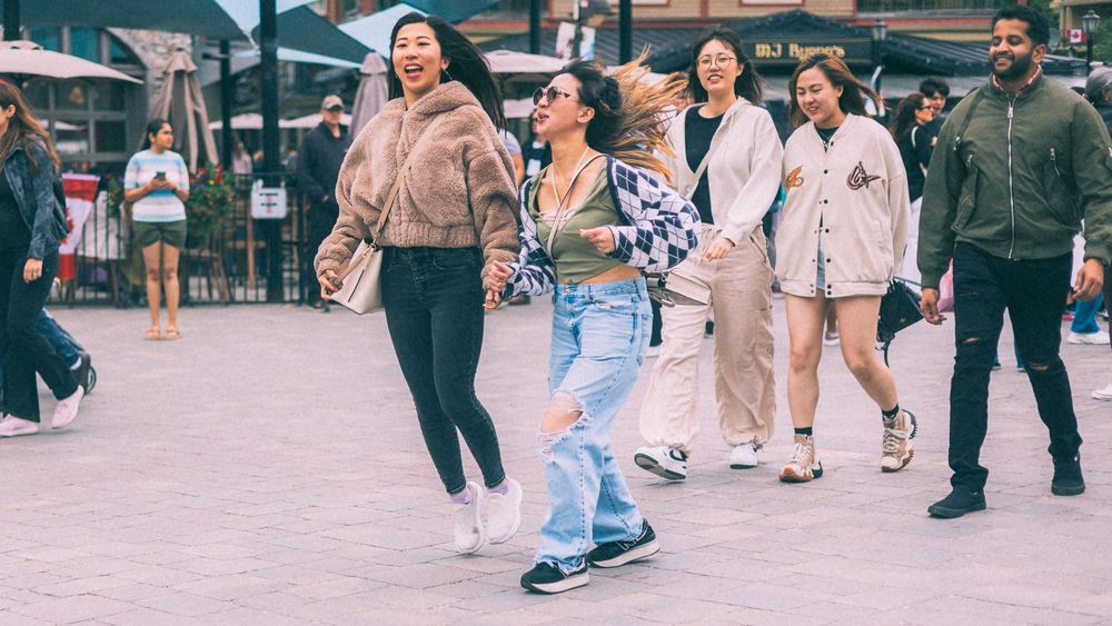 People walking along a busy outdoor shopping or entertainment area.