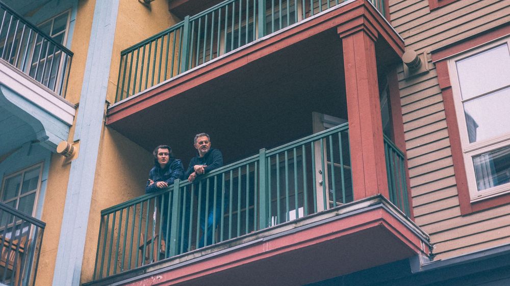 Exterior view of multi-level apartment balconies with colorful trim details.