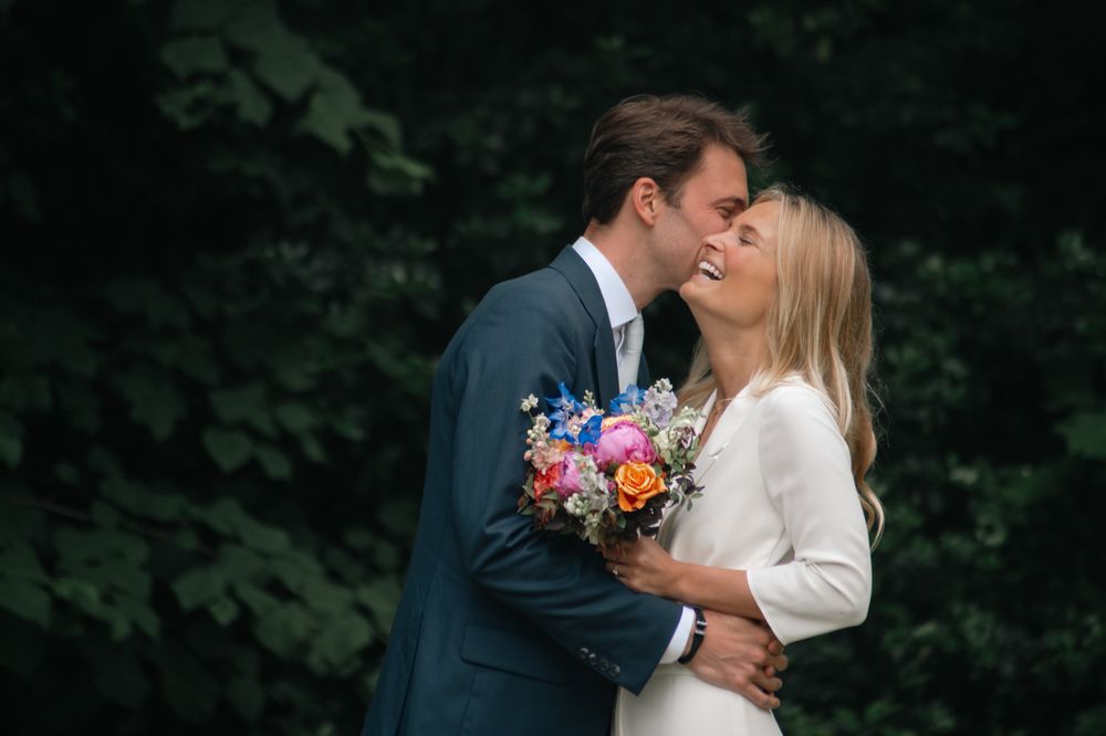 Romantic moment between newlyweds in formal attire outdoors.