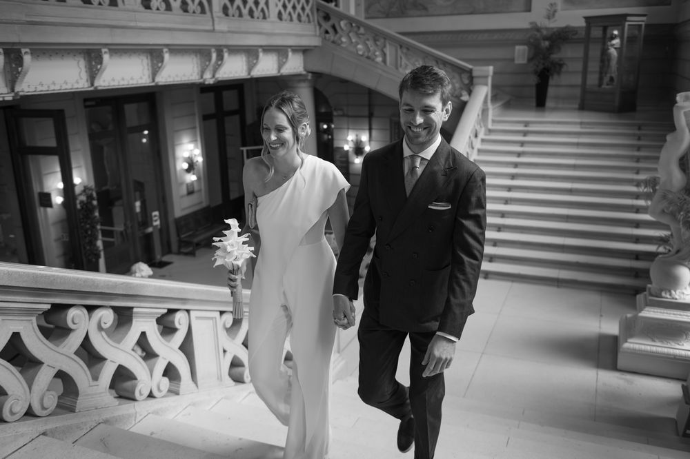 Elegant wedding couple walking together through ornate indoor venue.