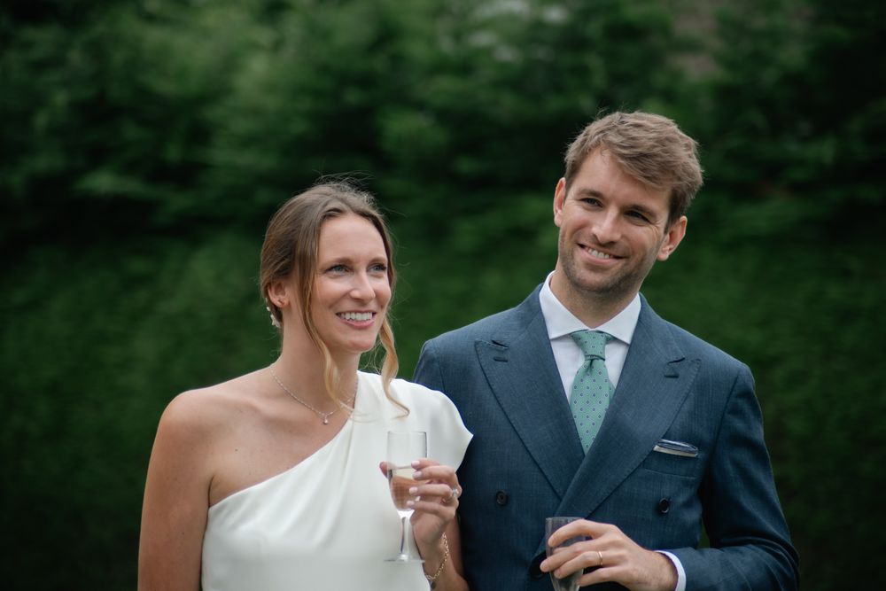 Outdoor wedding portraits with couple against green forest backdrop.