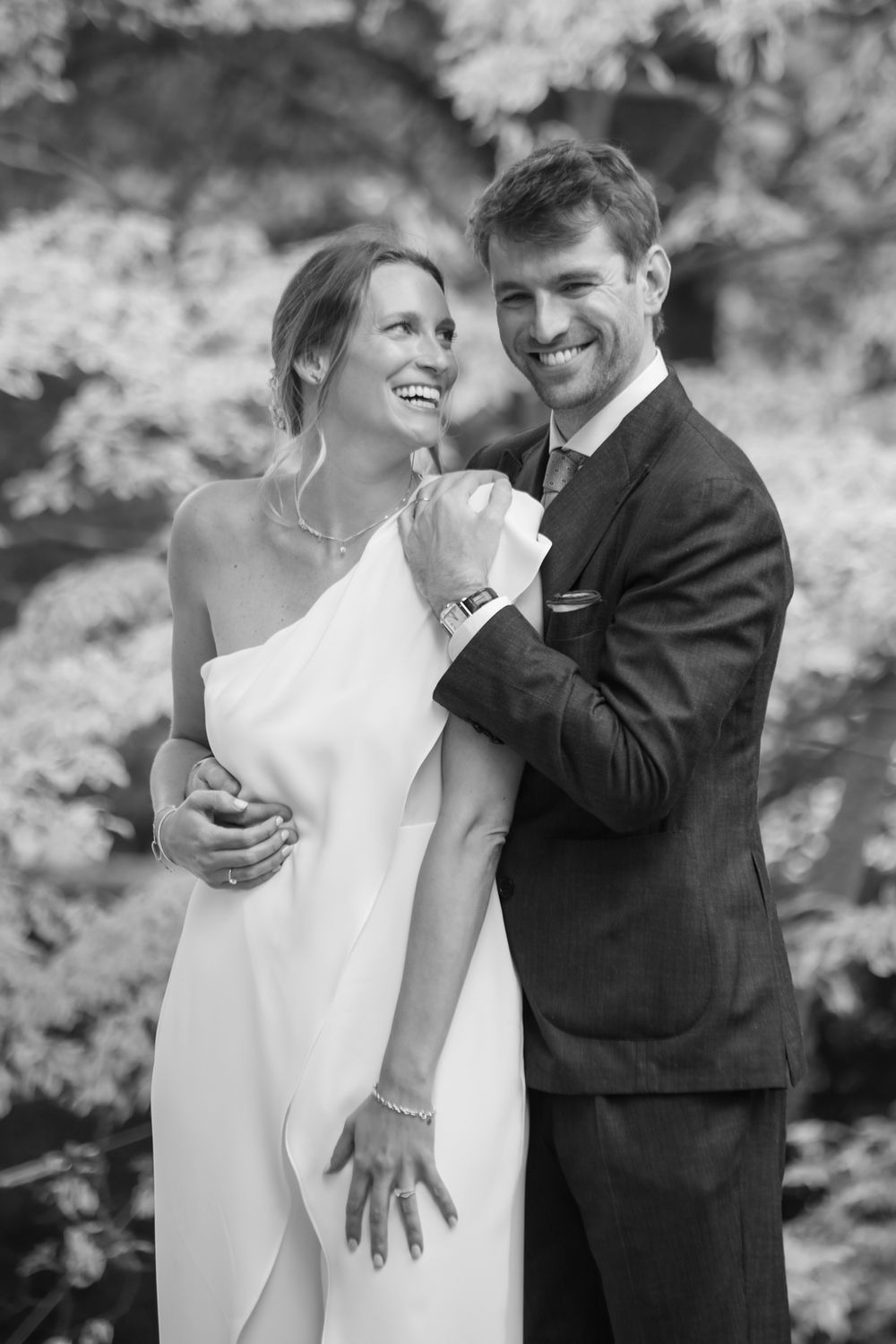 Black and white wedding photoshoot capturing natural laughter and happiness.