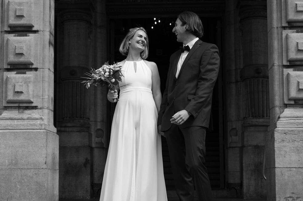 Black and white wedding portraits showing romantic moments outside historic building.