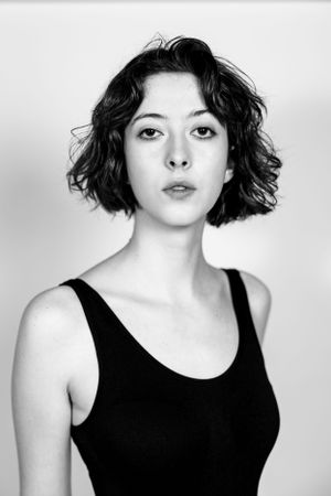 A black and white portrait of a woman in a black tank top. Model