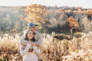 A sweet embrace captured in a field of tall grass during golden hour. Engagement Session CT
