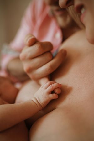 Close-up detail of tiny baby fingers grasping during an intimate moment.
