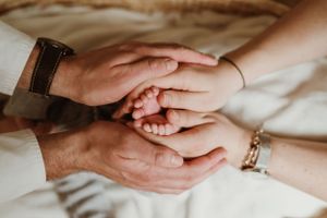 Close-up of gentle hands touching in intimate family portrait session.
