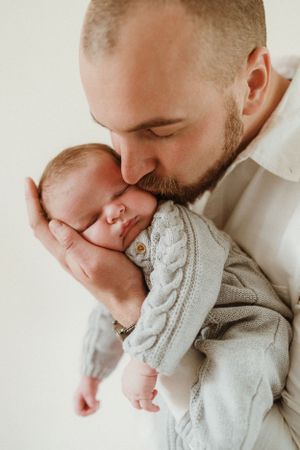 Close-up newborn photography with baby wearing soft grey knit sweater.