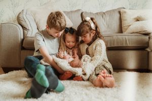 Candid family moments captured on a cozy living room floor.