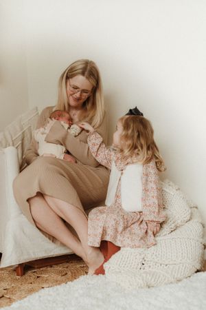 Intimate family moments captured on a cozy white knit blanket in soft natural light.