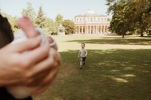 Sunny outdoor family scene with mansion and green lawn in background.