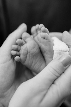 Black and white macro photo of multiple baby hands in a row.