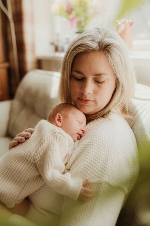 Intimate moments of rest and connection on a soft couch in natural window light.