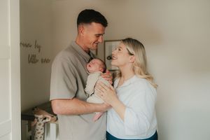 A series of intimate black and white photographs showing tender moments between a couple and their newborn baby.