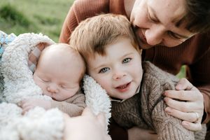 A tender family moment captured in black and white showing gentle embraces and joyful expressions.