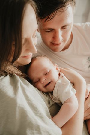 Intimate black and white portrait of family bonding with newborn.