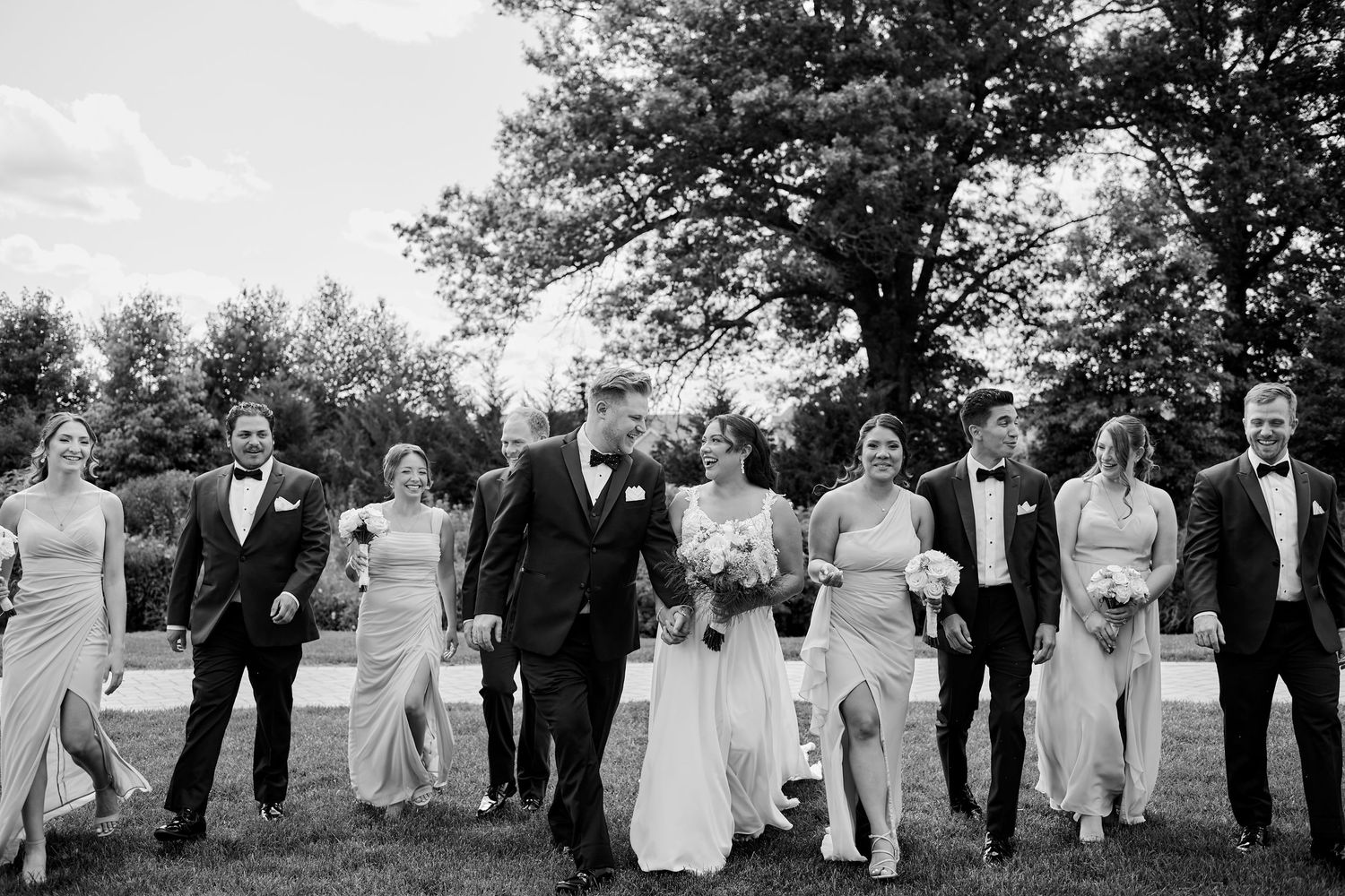 Bridal party in emerald green dresses holding vibrant pink bouquets.