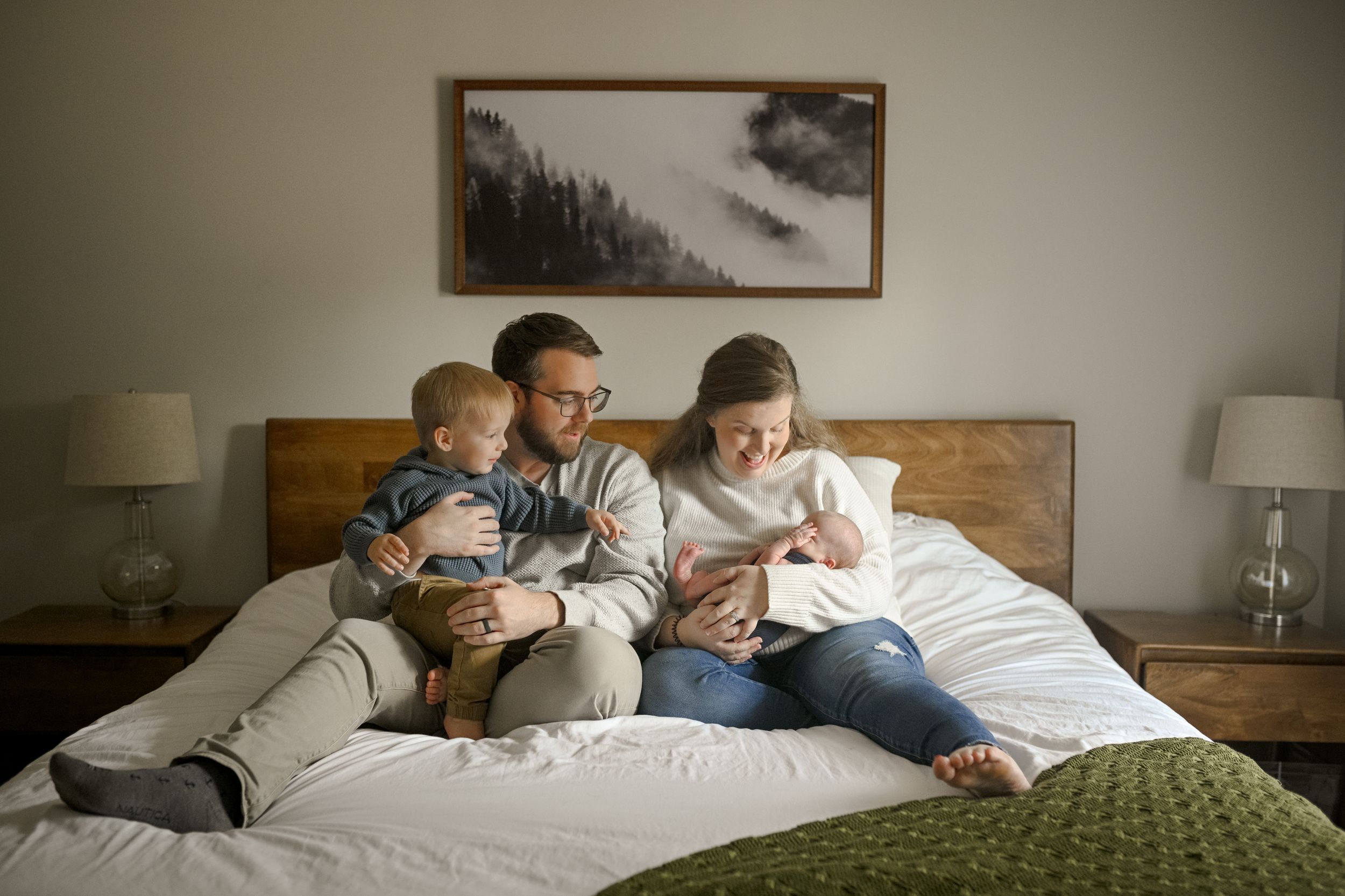 Intimate family moment reading together on a bed with natural lighting.