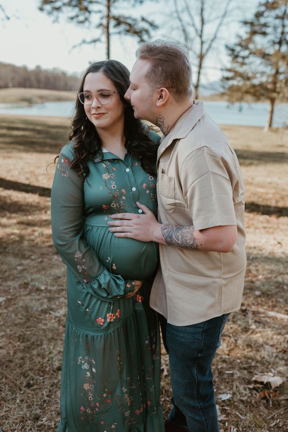 A couple shares intimate moments outdoors, with one wearing a green floral dress.