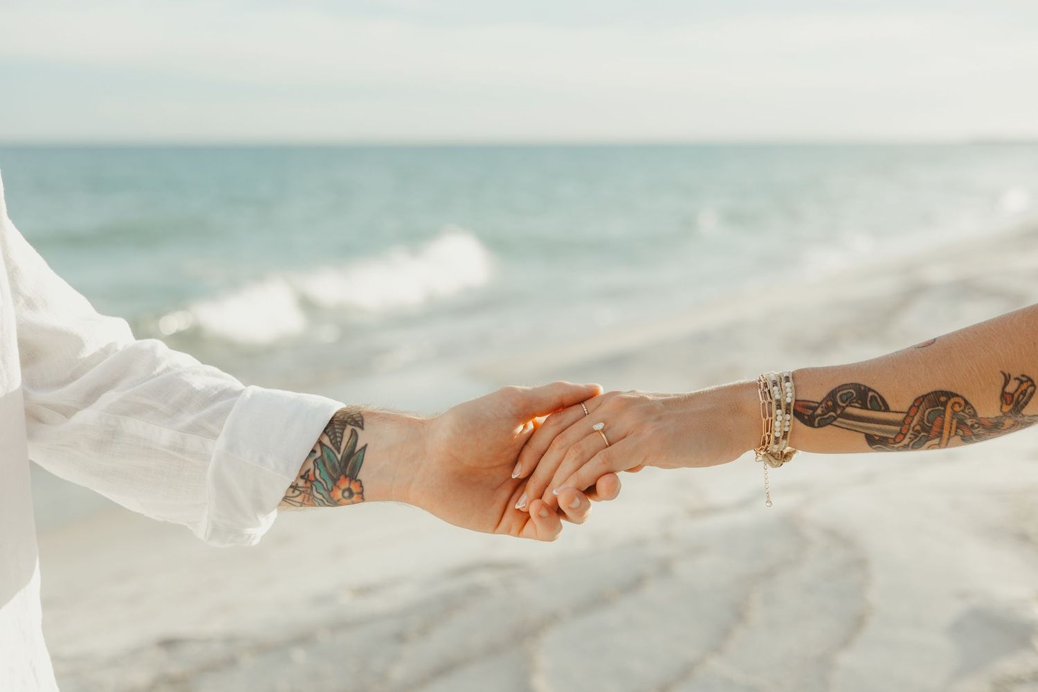 A series of close-up shots showing hands and feet resting on white fabric with soft natural lighting.